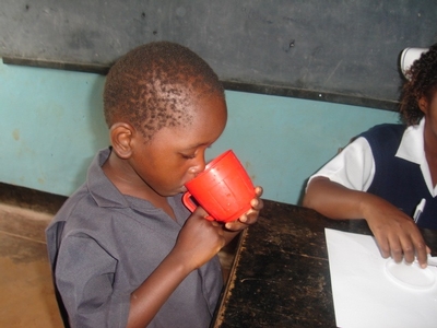 Image of boy in Zambia drinking from a cup
