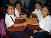 Picture of four young students at desks.