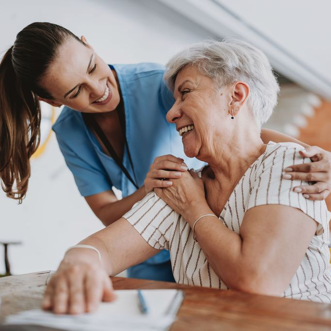 A medical professional and senior citizen laugh together