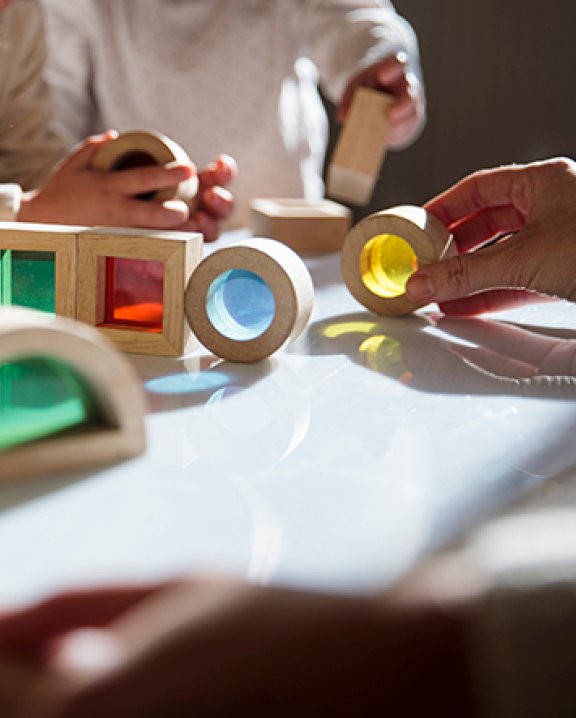 Children and teacher playing with colored blocks