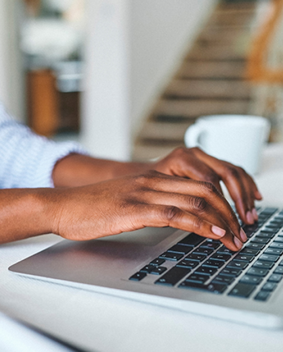 Woman sitting at a desk typing on a laptop