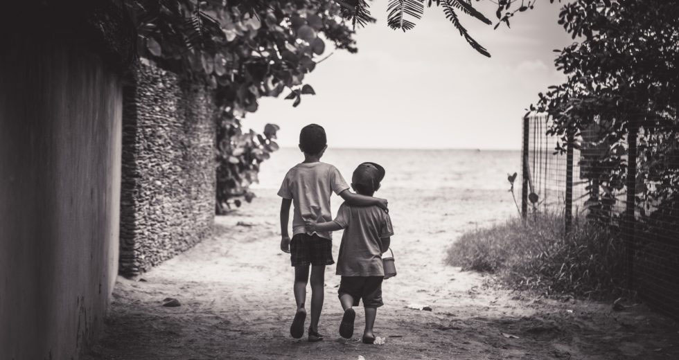 Image of two boys walking together, arm in arm
