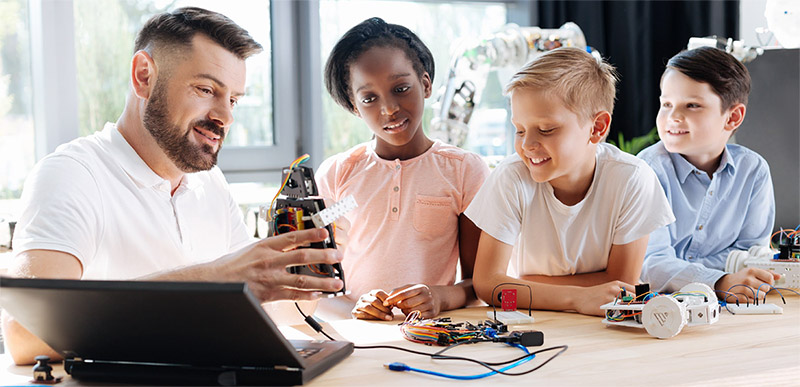 Image of teacher and students building a robot
