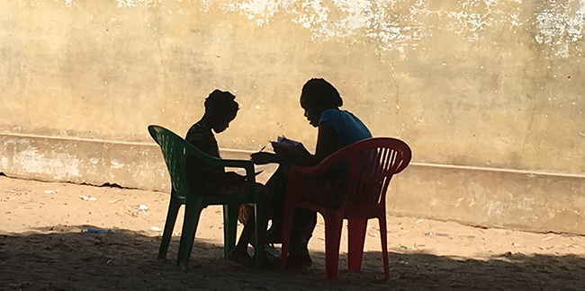 Image of adult and child reading in Mozambique