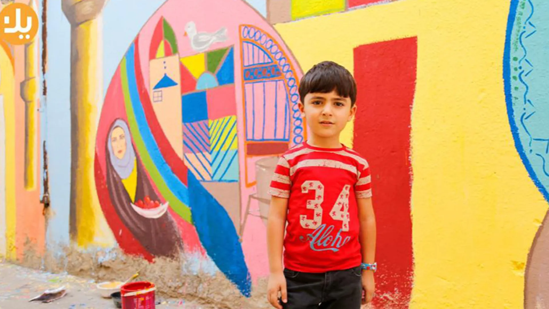 Boy in front of a colorful mural