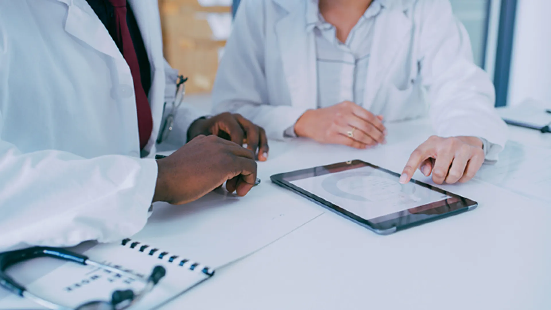 Doctors looking at graphs on tablet