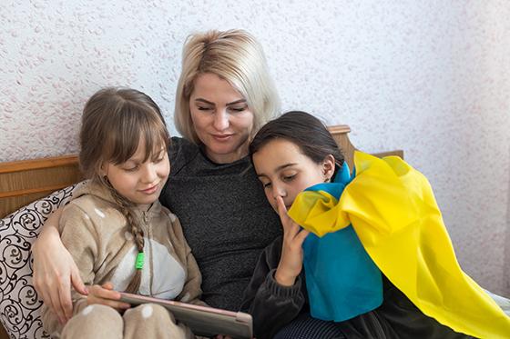 Ukrainian mother and daughters reading