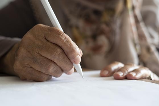 Closeup of older person's hand writing