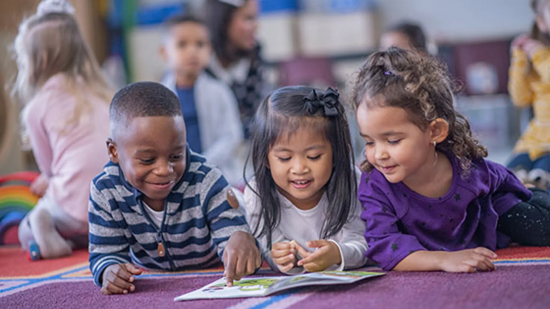 Three young children reading together