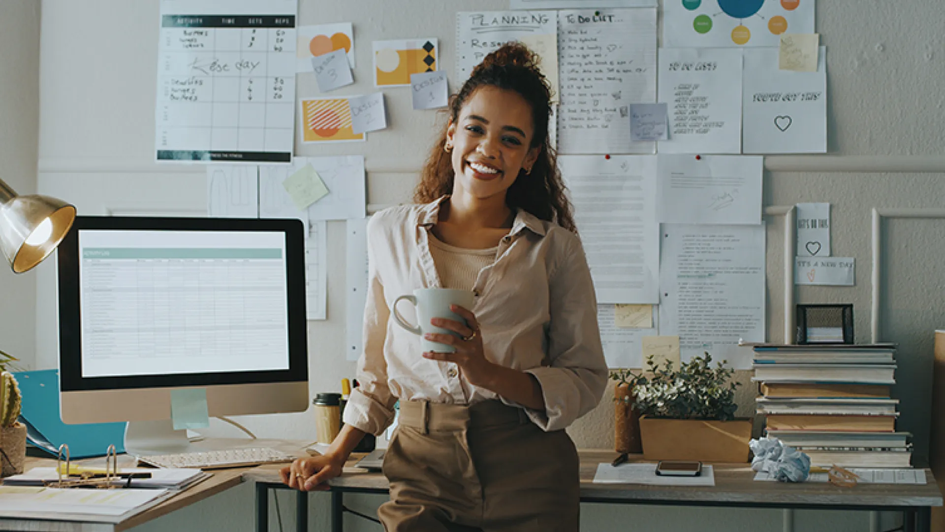Teacher standing in front of busy desk