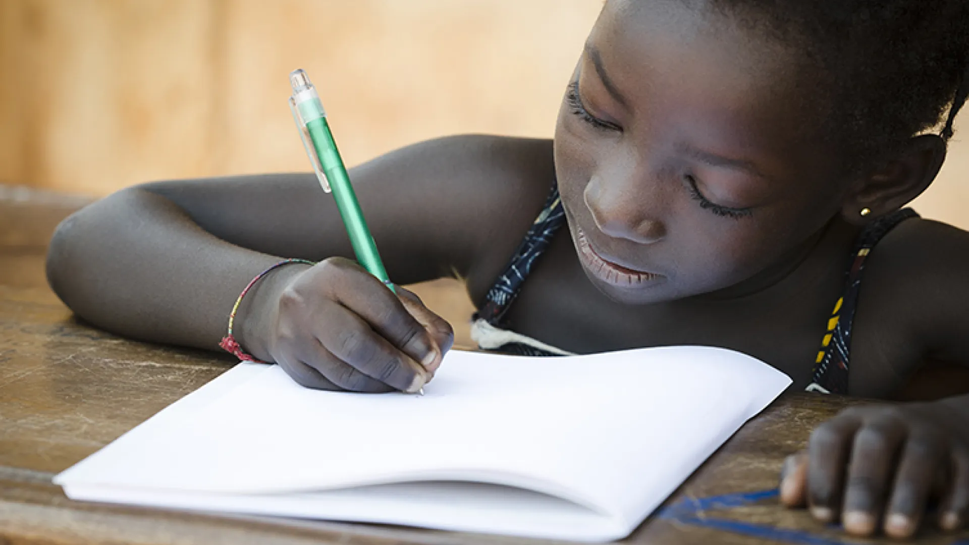 Young African girl writing in workbook