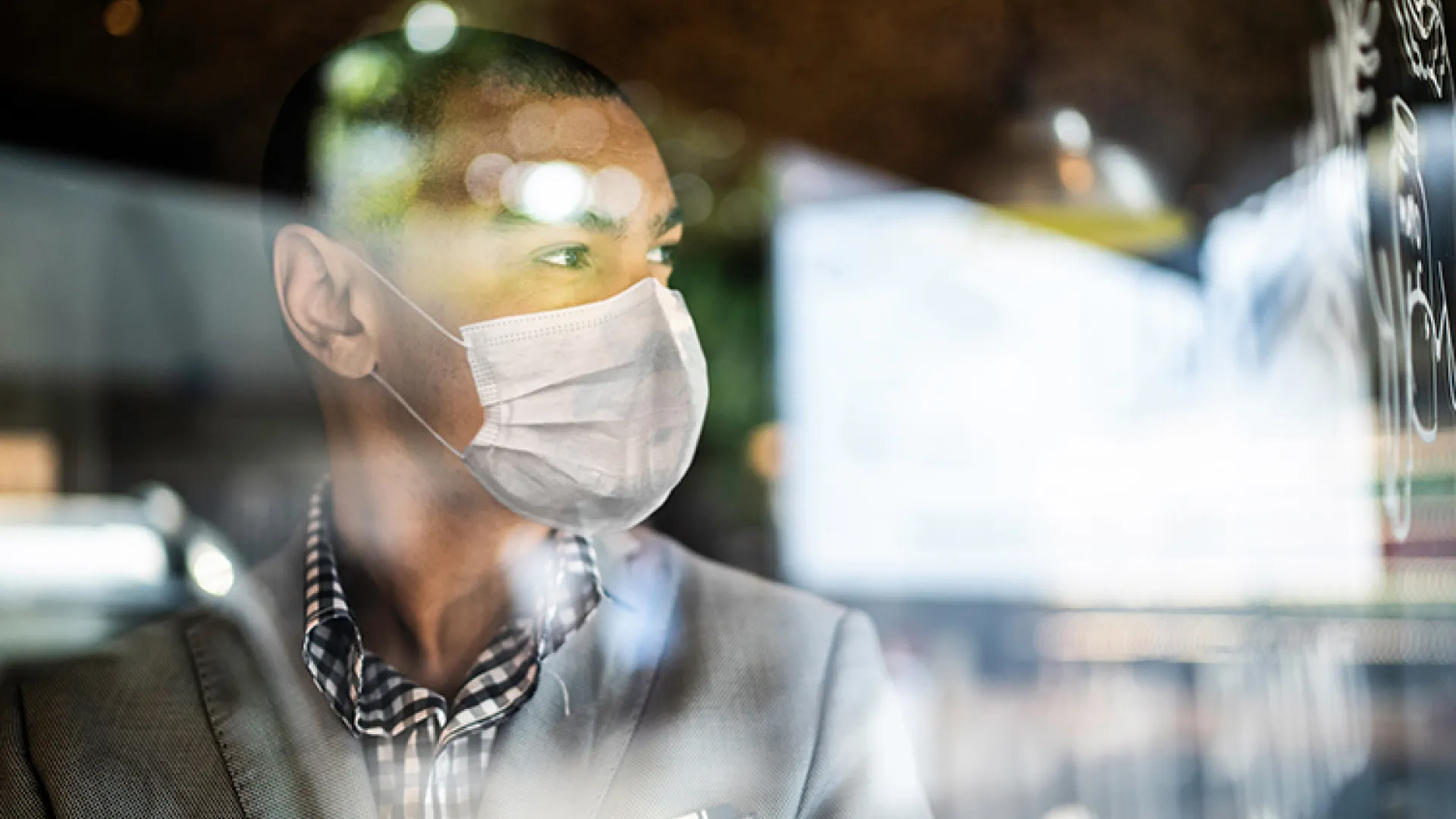 Man in mask looking out the window