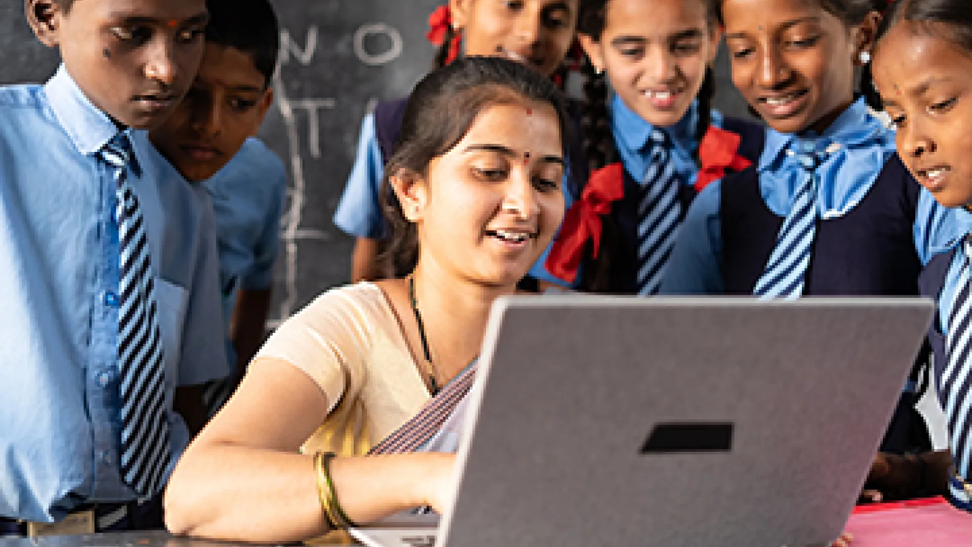 Indian teacher on laptop with students