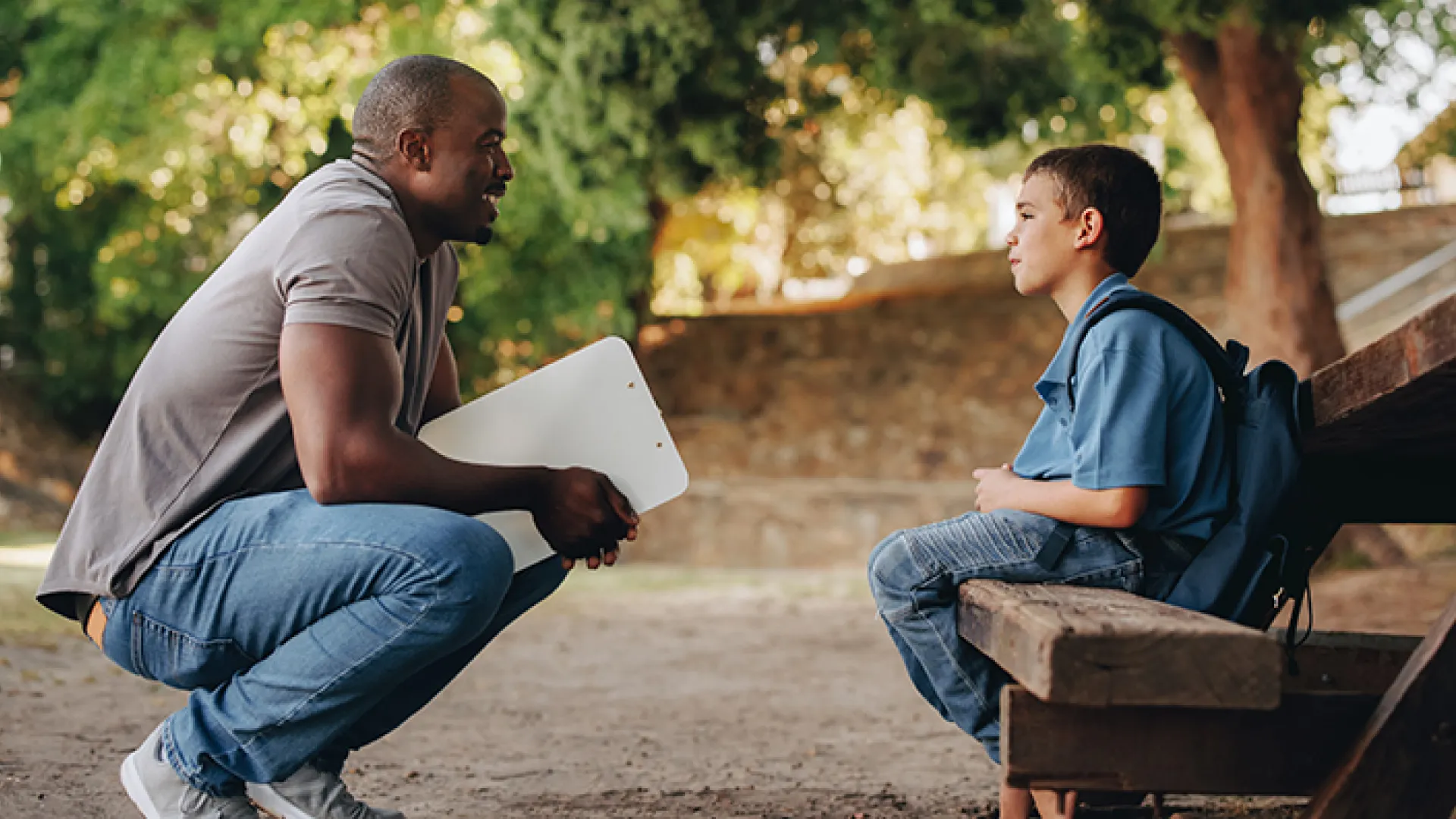 Mentor kneeling and talking to young boy