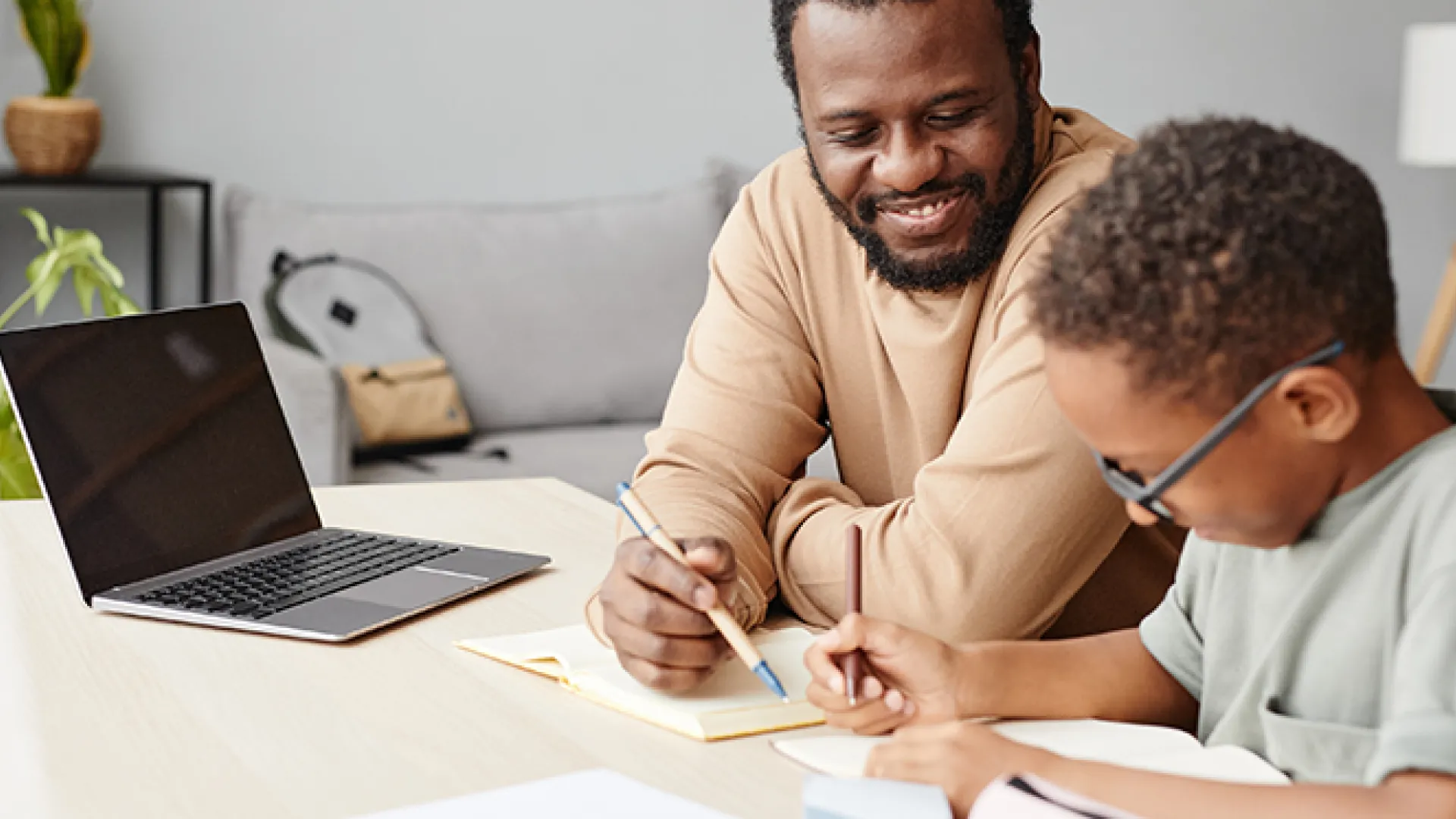 African American Boy Studying with Father at Home