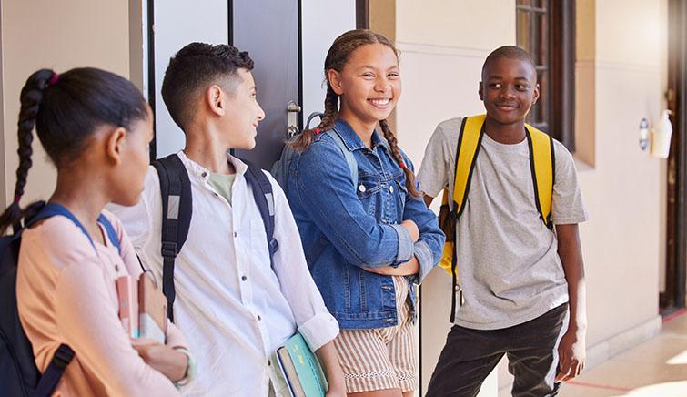 Happy teens by school lockers