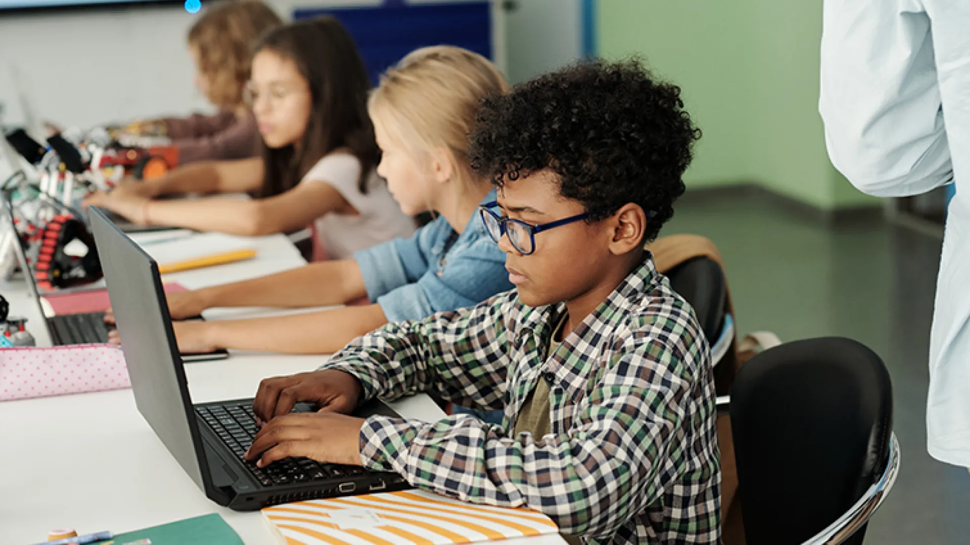 African American student working at a laptop at school