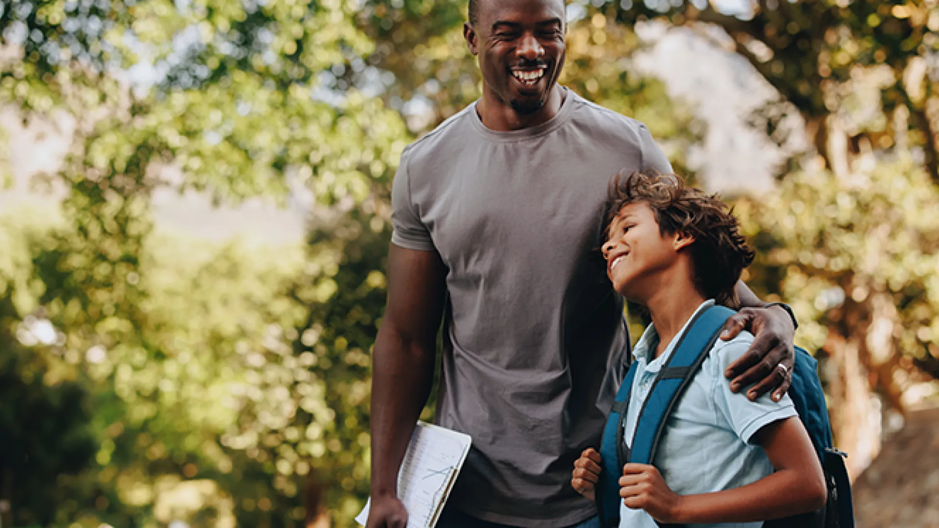 Happy student and teacher standing together outdoors