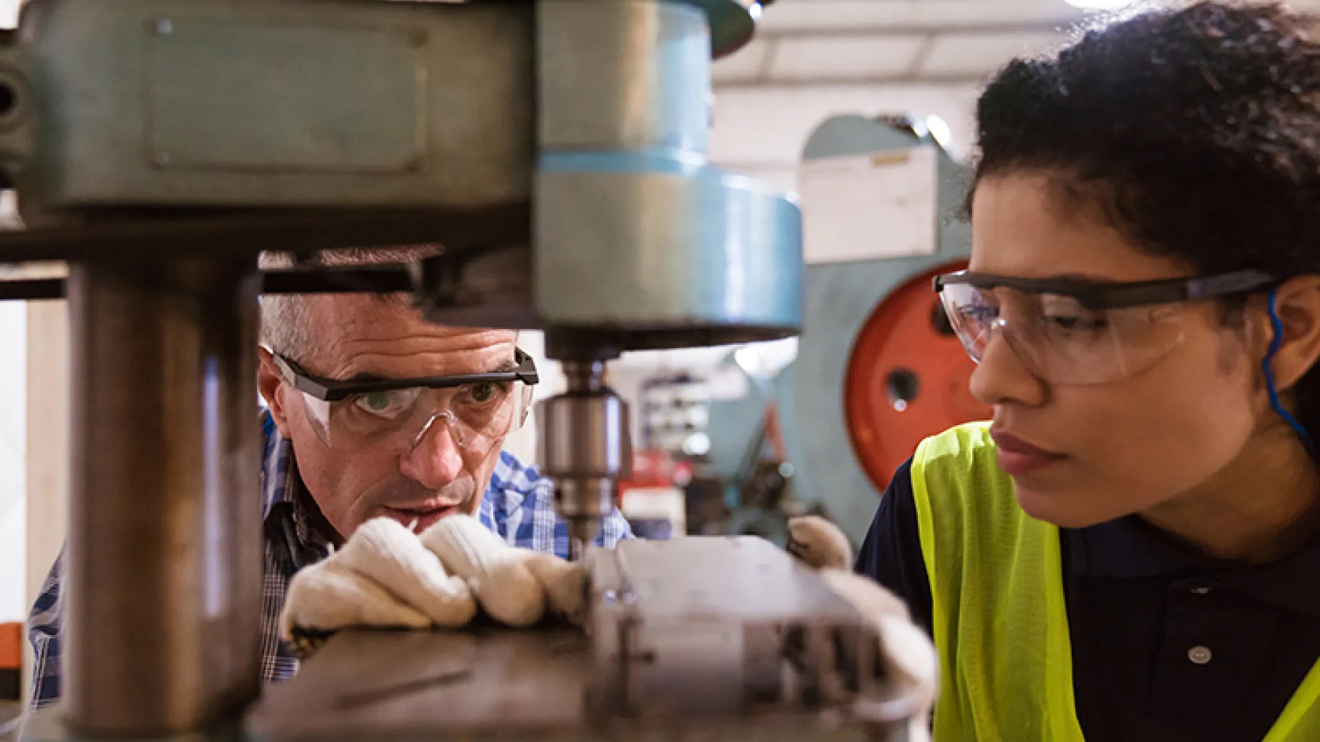 Apprentice and mentor with heavy machinery