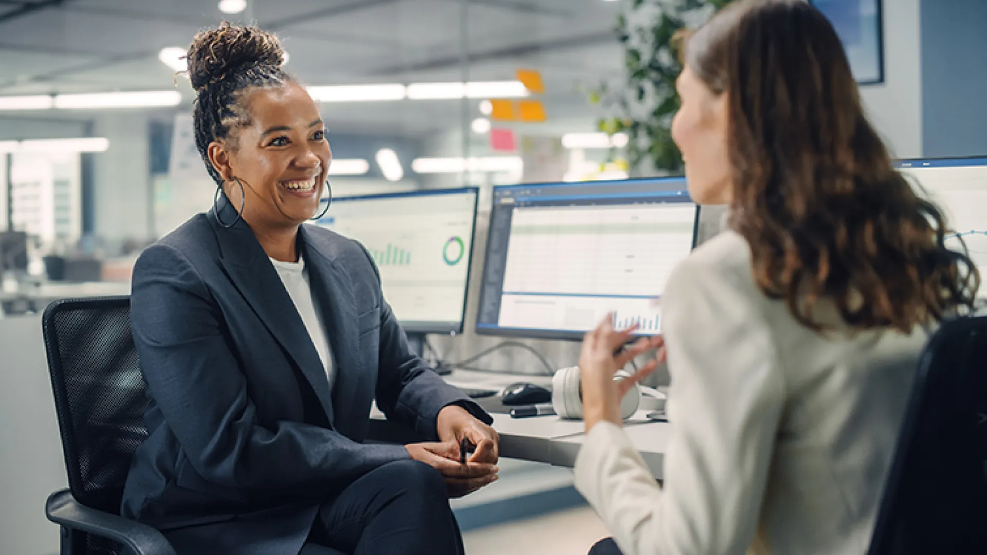 Female colleagues chatting at desk