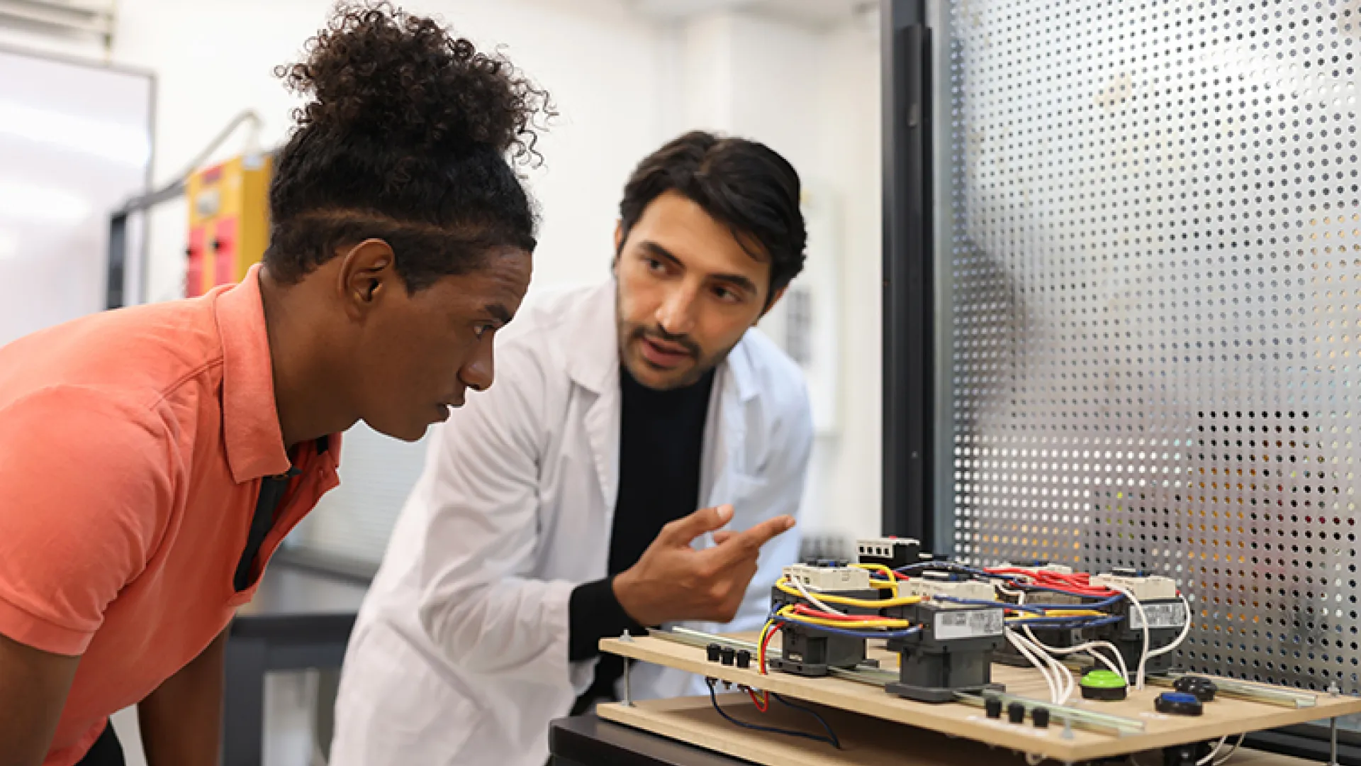 Teacher and student working on an engineering project in a classroom