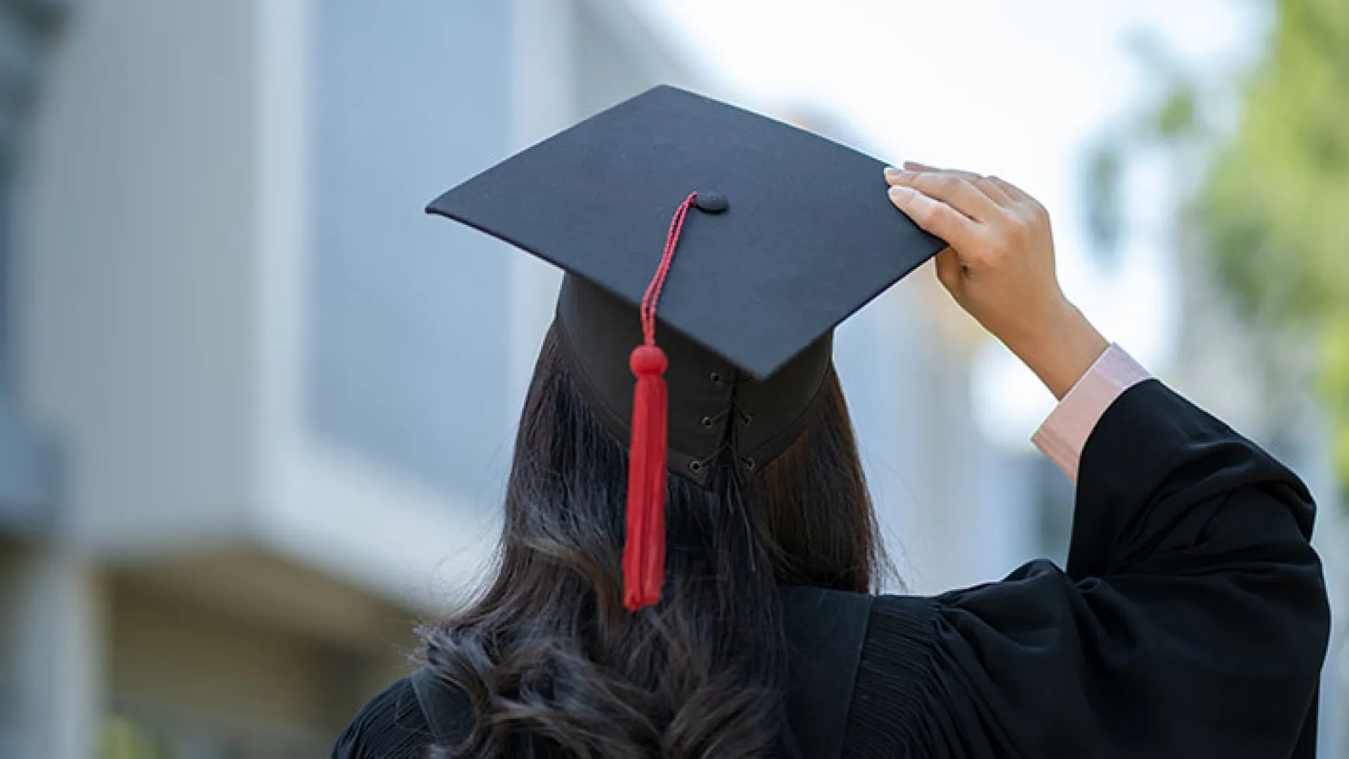 Back of graduate holding her mortarboard