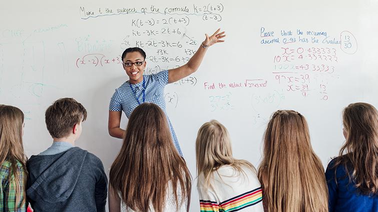 Teacher at whiteboard with math students