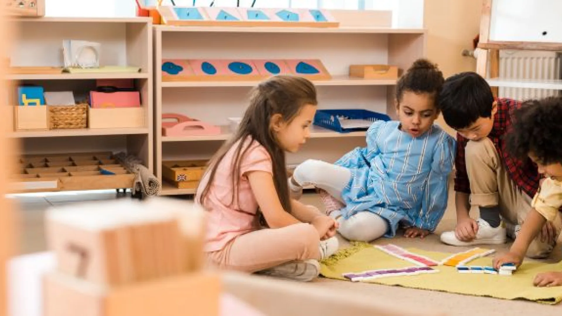Four children sitting on floor making a color pattern 