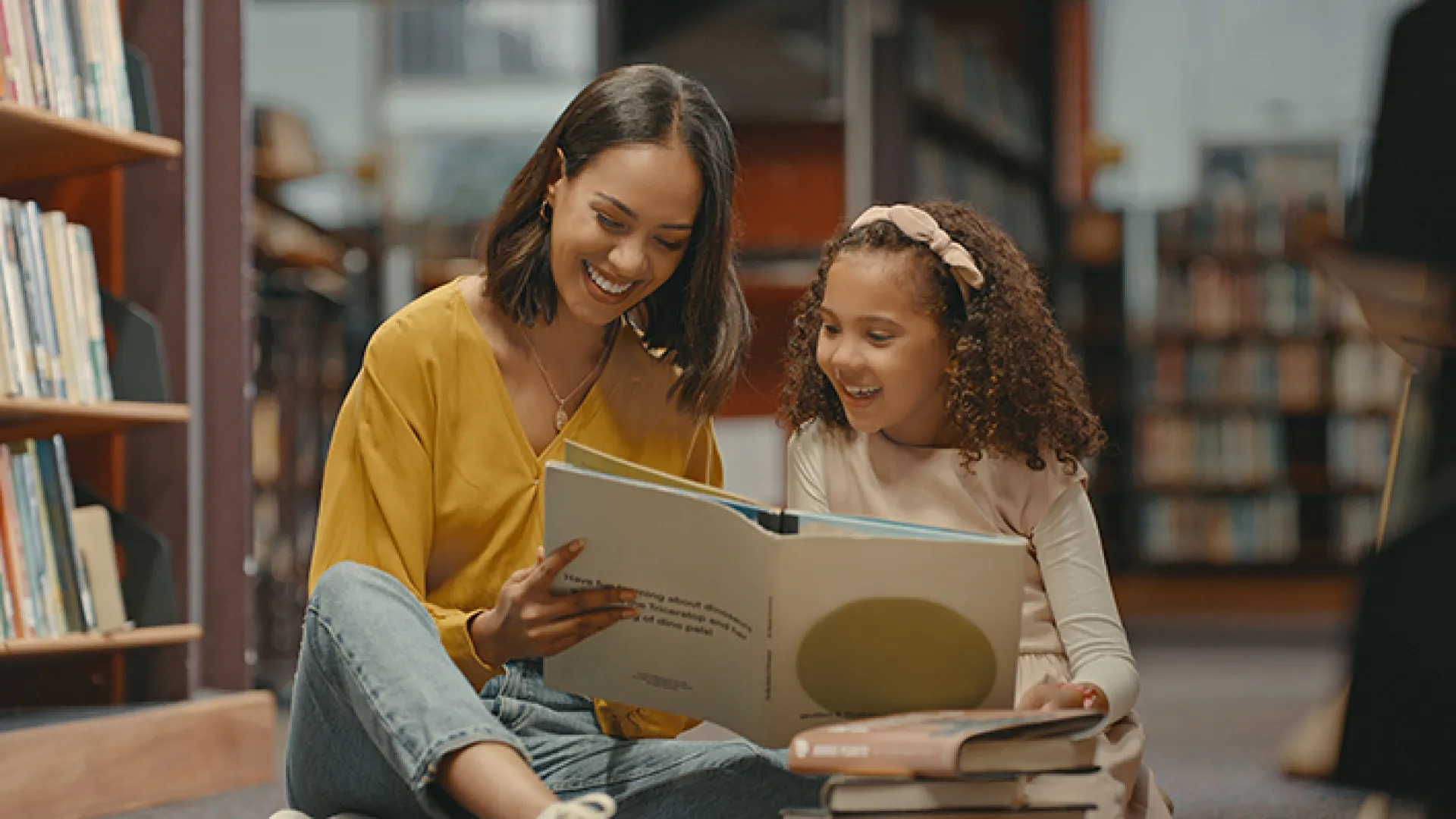 Mother and daughter reading together in library