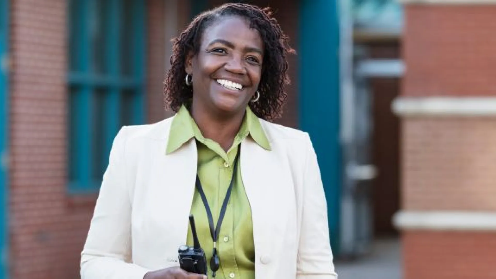 Principal outside a school holding a radio