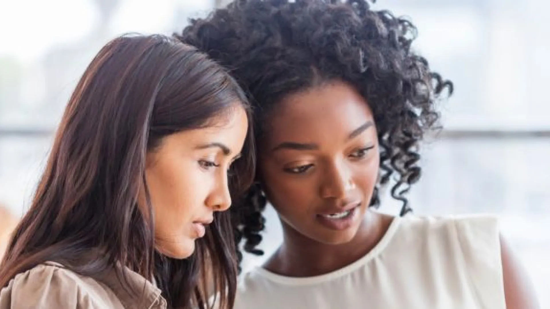 two women looking at a tablet together