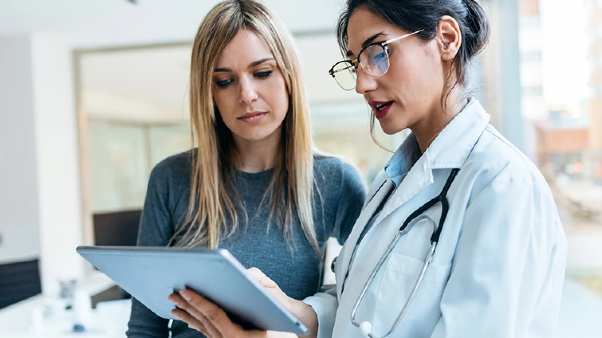 doctor talking while explaining medical treatment with digital tablet to patient in the consultatio
