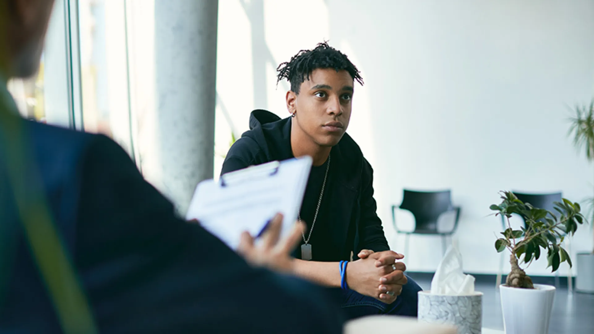 teen boy meeting with adult with clipboard