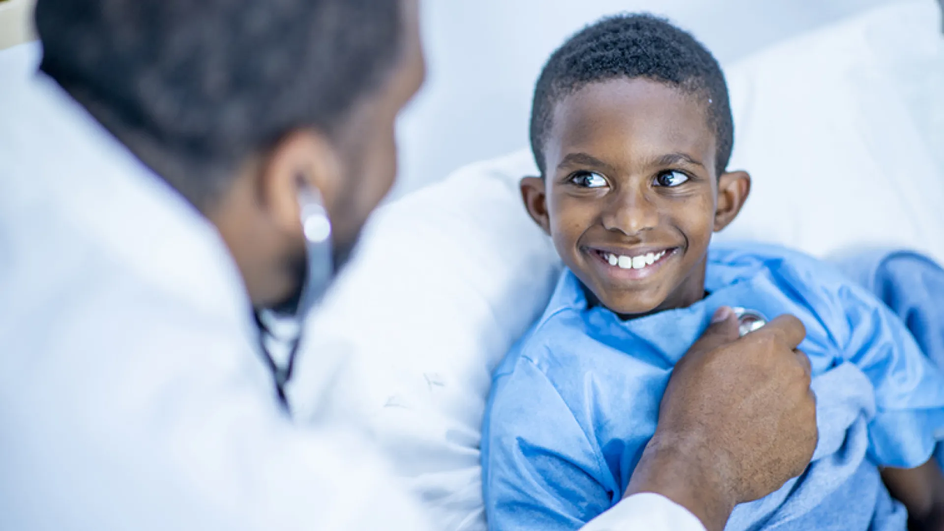 doctor using stethoscope on young patient