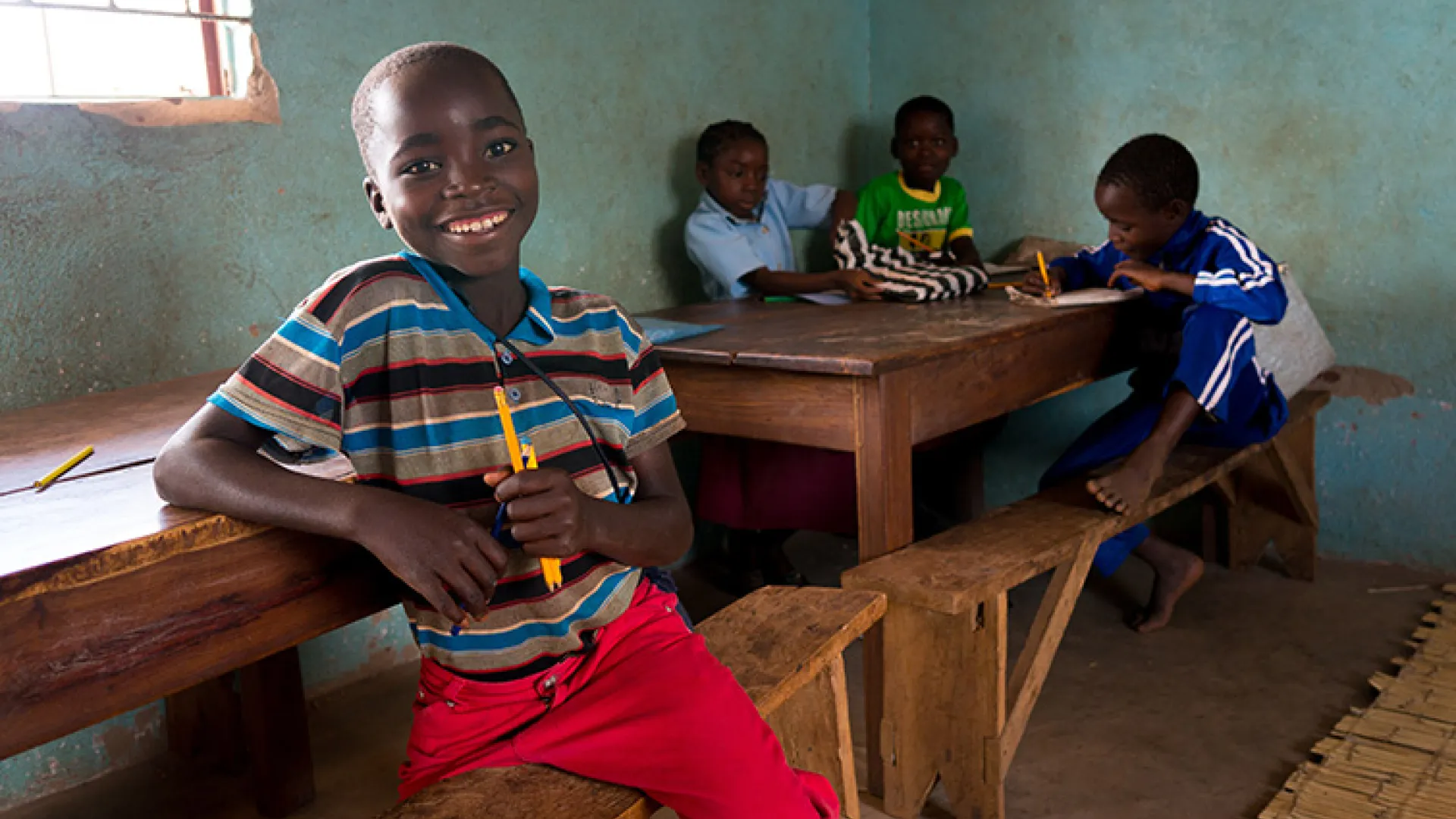 Boy smiling in Zambian classroom
