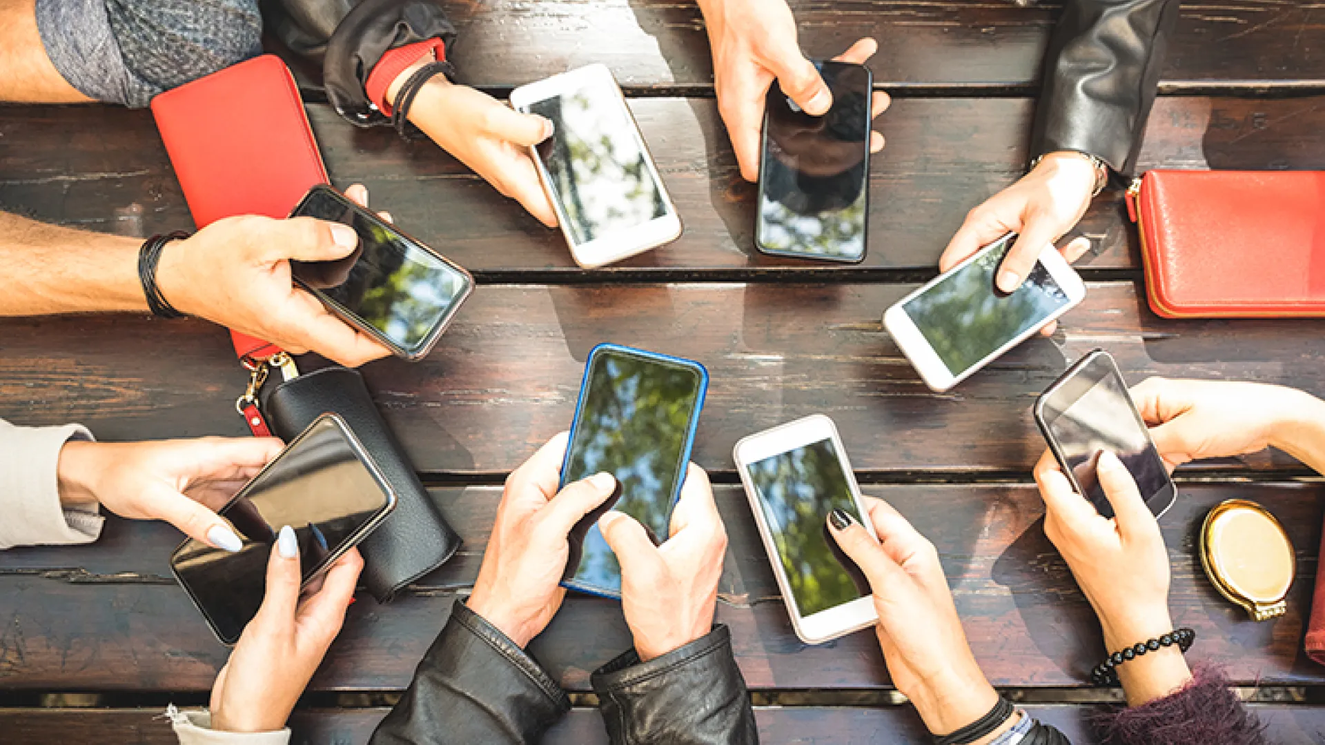 circle of hands holding cell phones