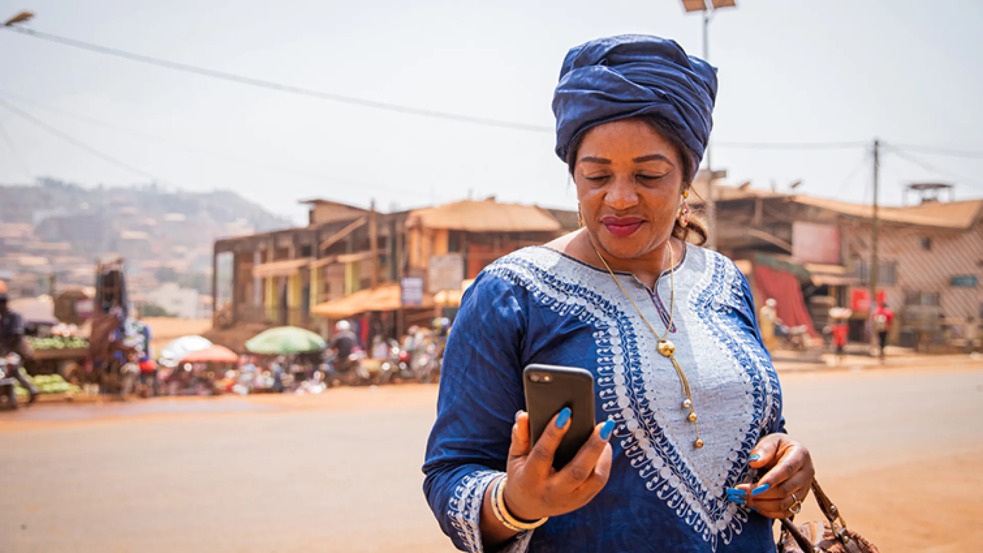woman in traditional african dress looking at phone