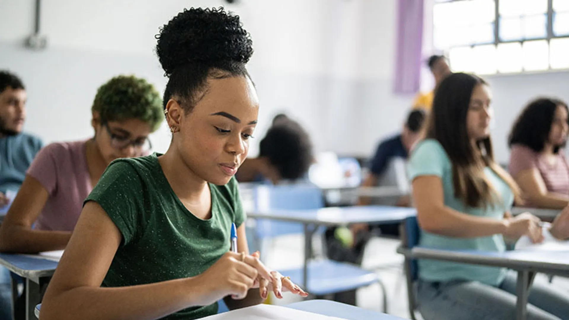 Young woman studying at classroom desk