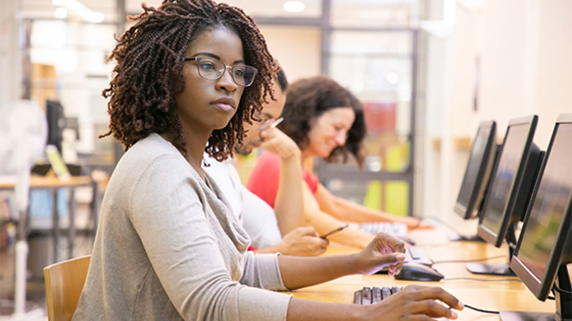 Young woman at row of computers