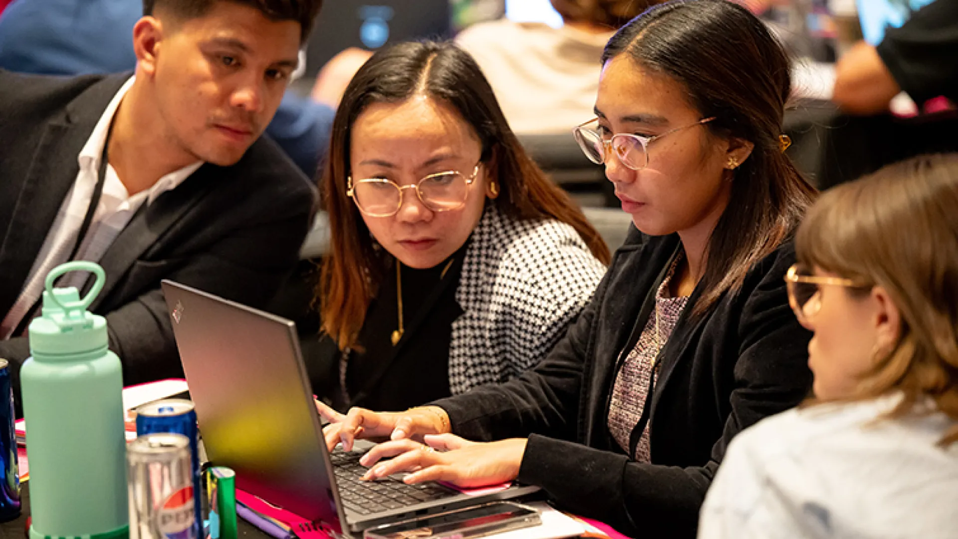 participants in Season of CS event looking at laptop together