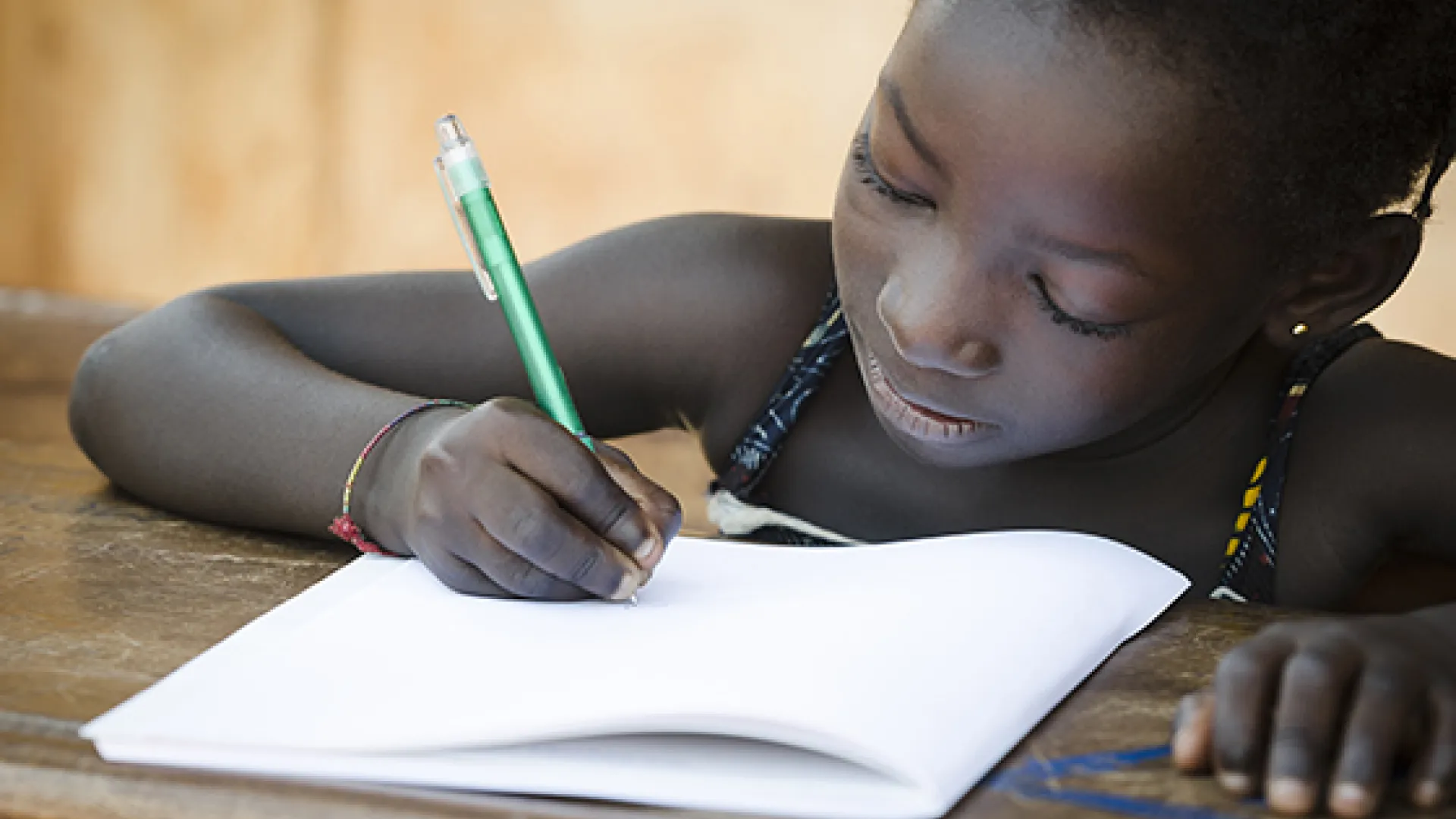 Young African girl writing in workbook