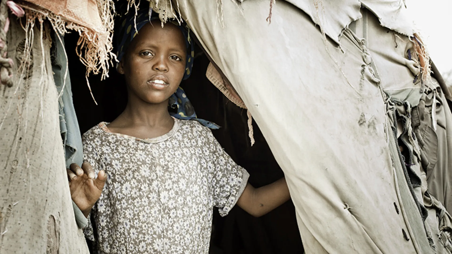 young Somali girl looks out of tent