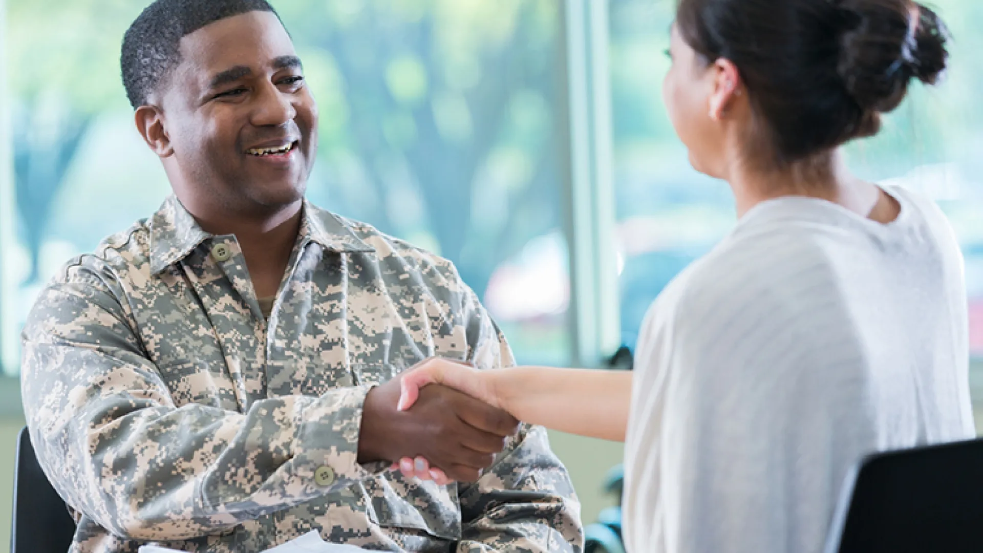man in military uniform shaking hands
