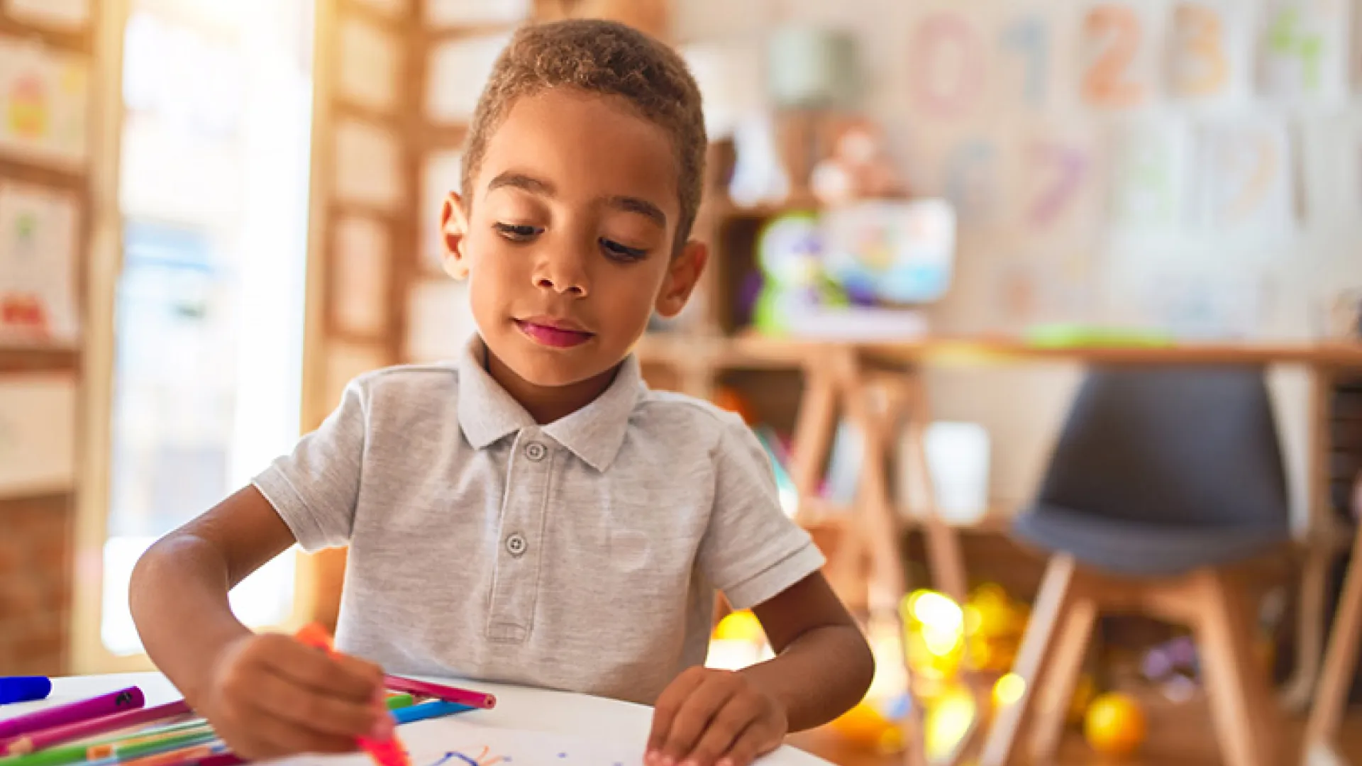 boy coloring in preschool