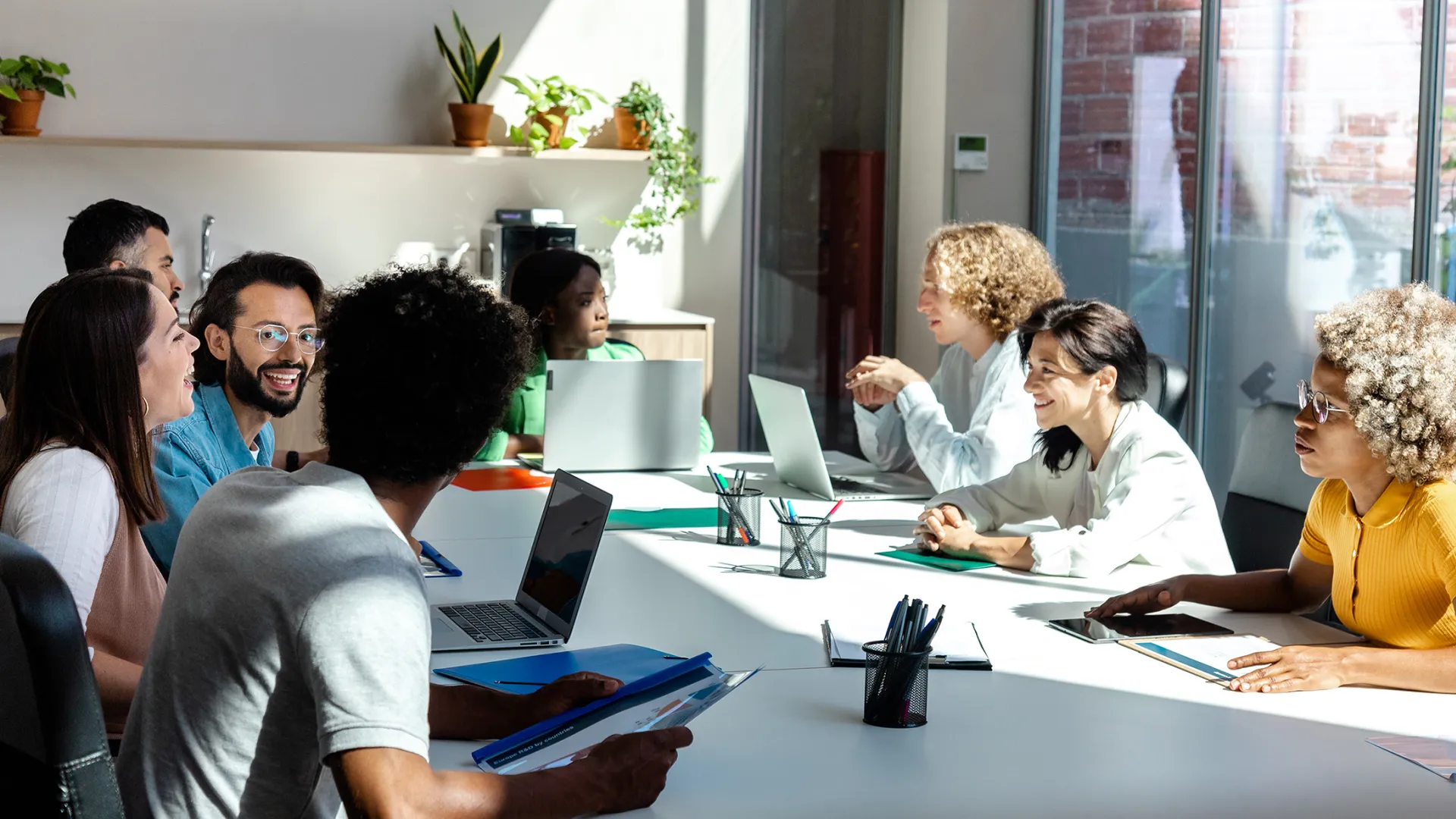 Group of young researchers in sunny conference room
