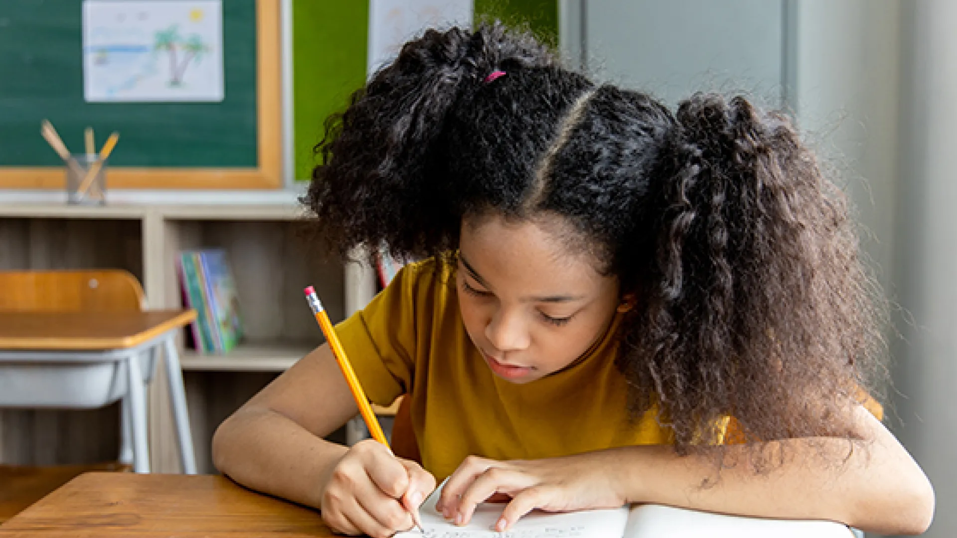 Girl by window writing in a notebook
