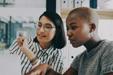 Colleagues work together at a laptop