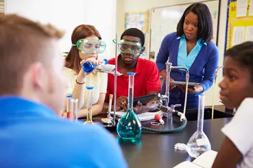 Teacher and high school students in chemistry lab