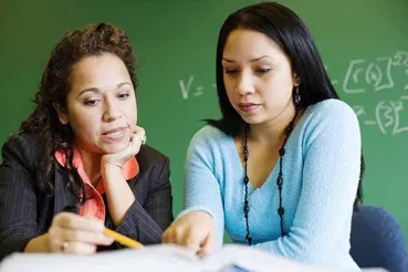 Two teachers talking in a classroom