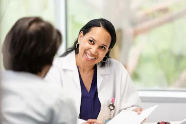 Healthcare worker with patient at desk